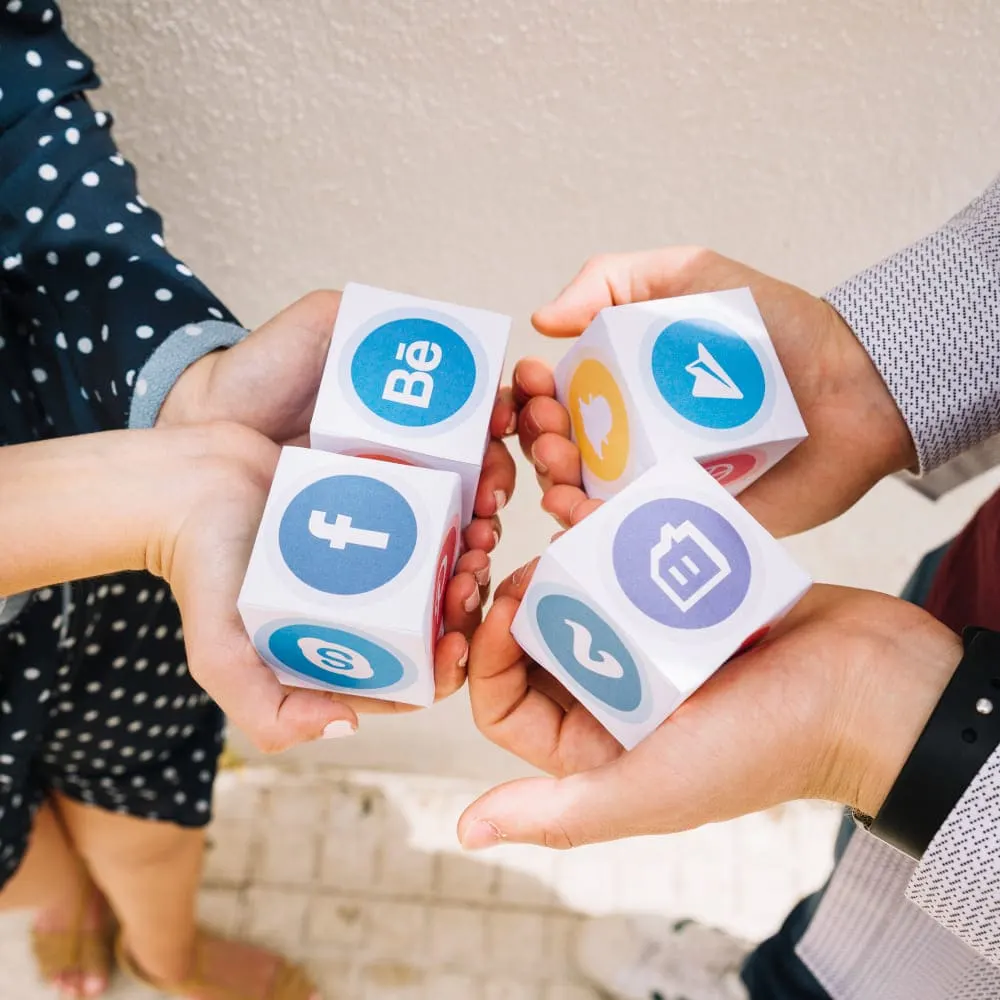 Team holding cubes with social media icons representing social media optimization services and strategies